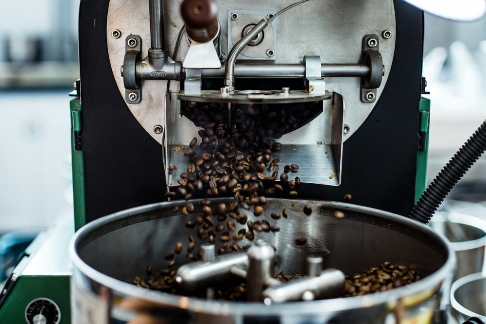 Roasted coffee falling from the roaster into the cooling tray